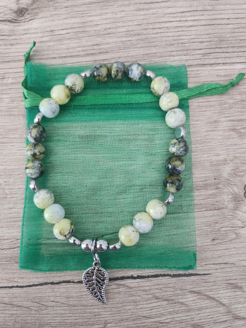 Bracelet en perles vertes, jaunes et grises, intercalaires argentés et breloque feuille