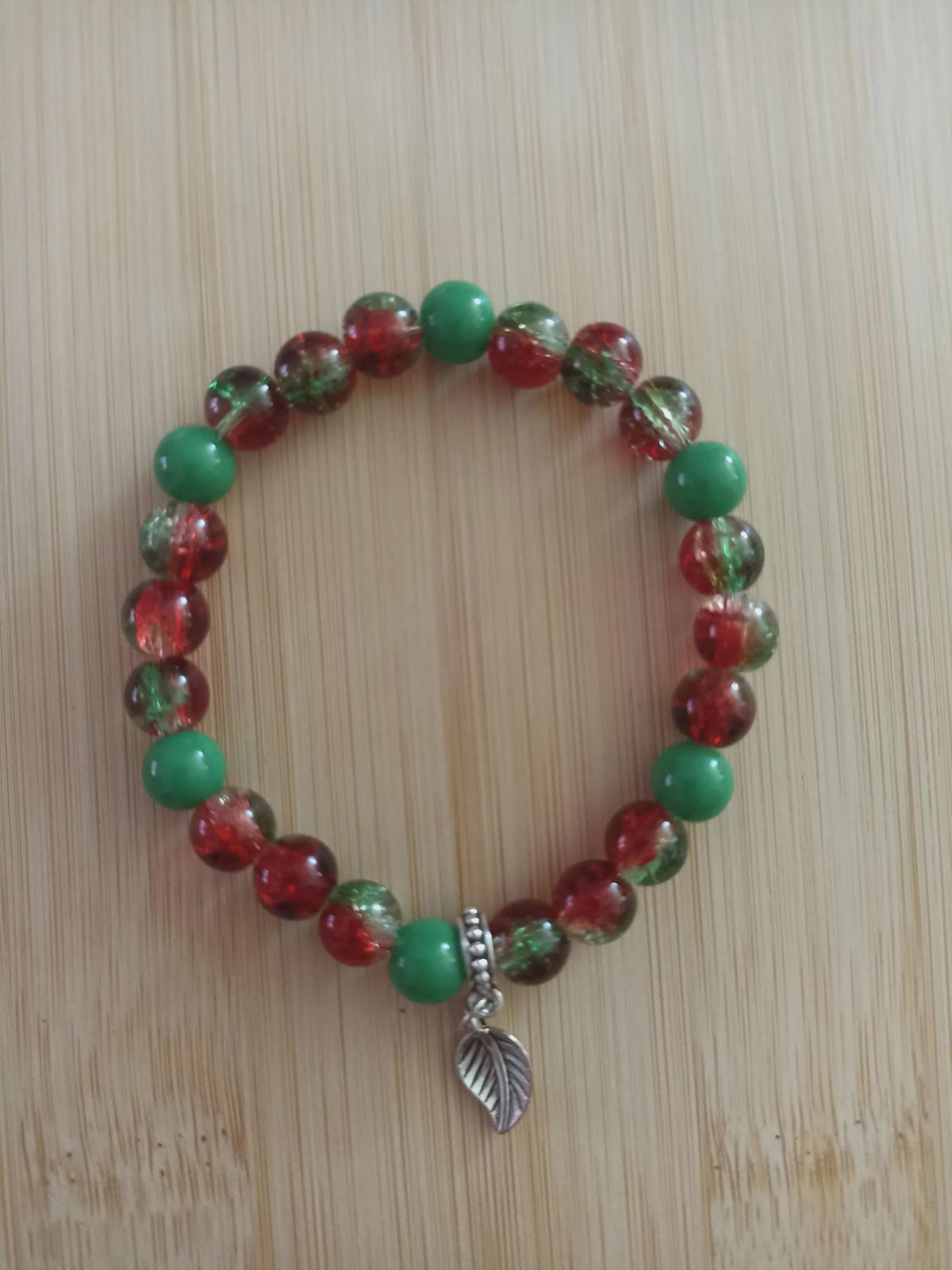Bracelet artisanal Fusion, perles rouges et vertes, breloque feuille