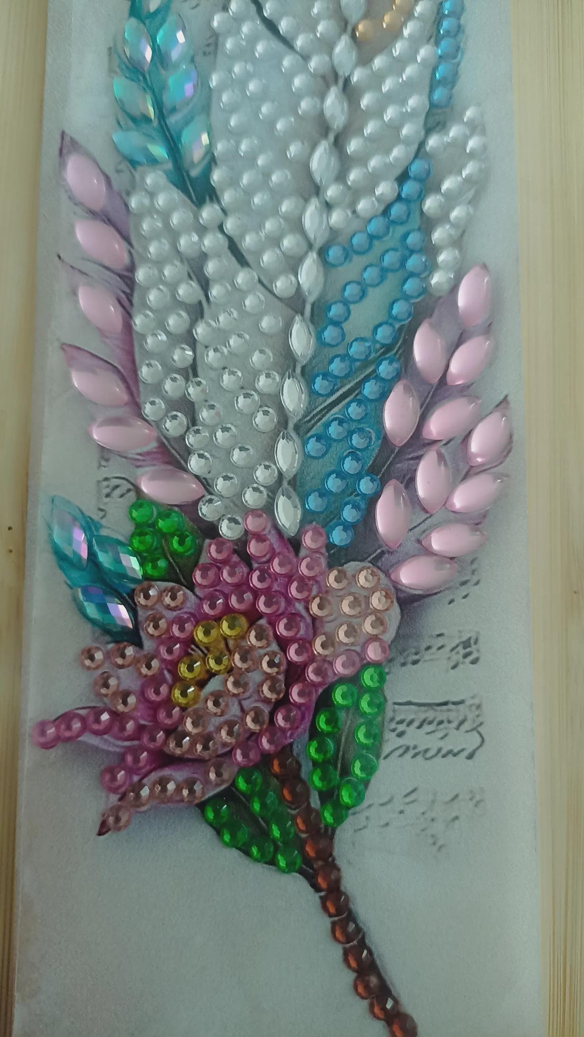 Marque-page artisanal en diamond painting,  avec plumes nacrées, fleurs, touches de bleu, rose et vert - "Evanélya " -