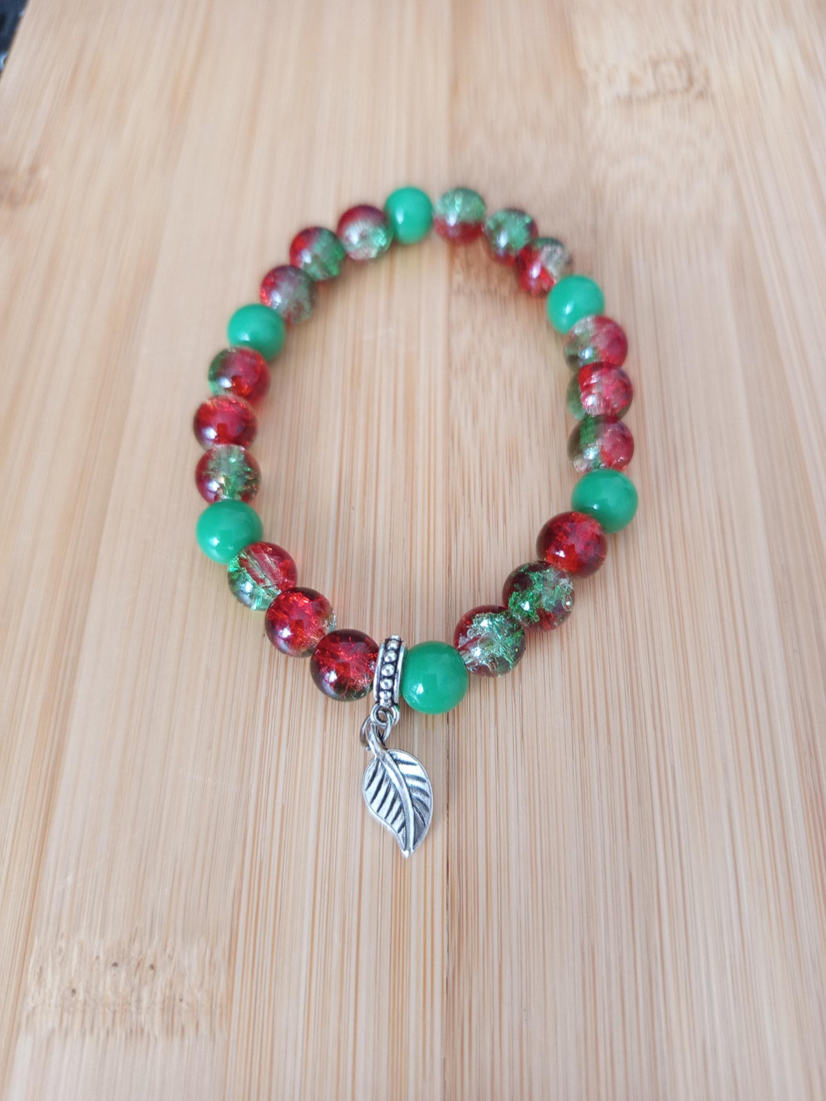 Bracelet artisanal Fusion, perles rouges et vertes, breloque feuille