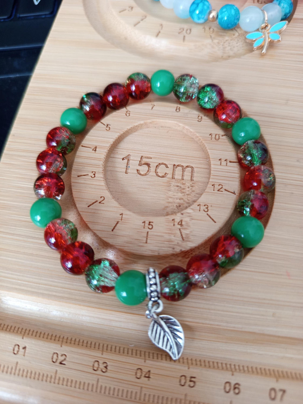 Bracelet artisanal Fusion, perles rouges et vertes, breloque feuille