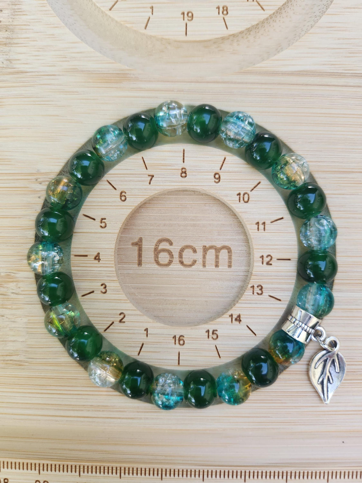 Bracelet en perles vertes et bleutées avec breloque feuille,
