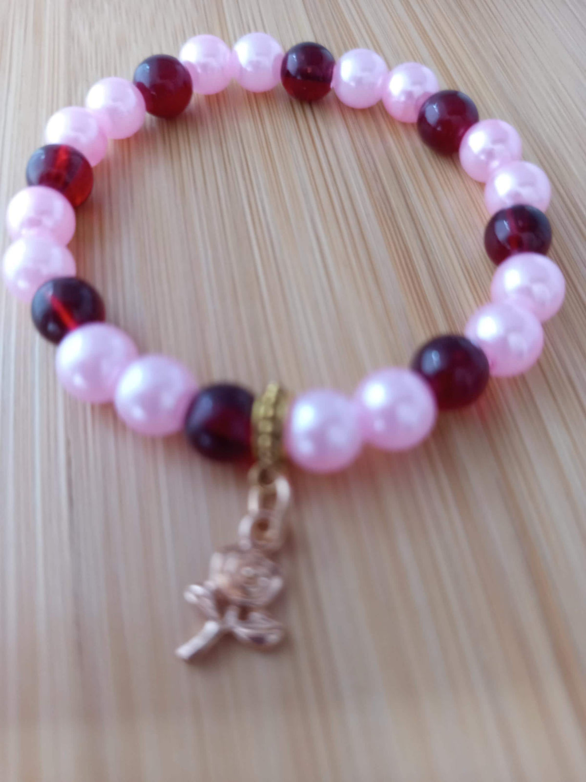 Bracelet artisanal Mallow, perles roses et bordeaux, breloque florale