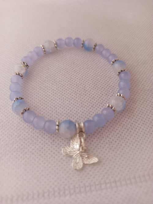 Bracelet en perles lavande, blanches et translucides avec breloque papillon -